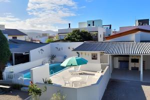 an aerial view of a house with a swimming pool and an umbrella at Condomínio Villa do Oceano in Garopaba
