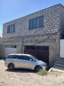 a silver car parked in front of a brick building at Апартамент in Yerevan