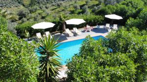 a swimming pool with umbrellas and chairs and a person at Sobremesa Boutique in Sayalonga