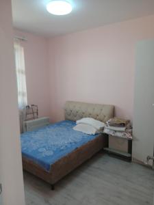 a bedroom with a bed with a blue comforter at Апартамент in Yerevan