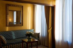 a living room with a couch and a mirror at Hotel Pensione Wildner in Venice