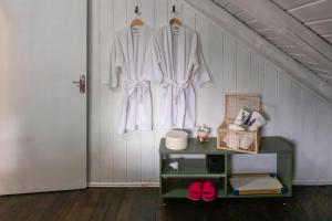 a white robe hanging on a wall next to a door at Sítio Temporada in Guabiruba +62 photos