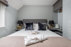 a bedroom with a bed with a book and pillows at LUXURIOUS Country Rooms in Hurley - THE FOX in Hurley