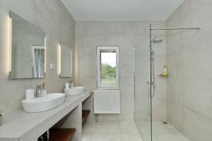 a bathroom with two sinks and a glass shower at Villa Demare with Heated Pool, Free EVC Station in Lovinac +117 photos