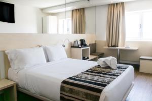 a hotel room with a large bed and a tv at Park Hotel Porto Valongo in Valongo +28 photos