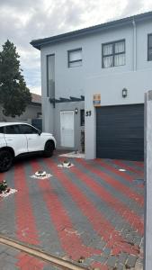 a white car parked in front of a white house at Demmys Comfort in Cape Town