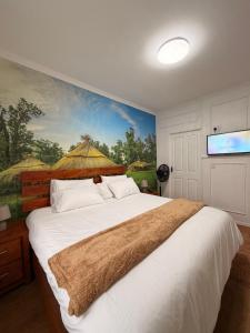 a bedroom with a large bed with a painting on the wall at Demmys Comfort in Cape Town +17 photos