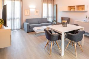 a living room with a table and chairs and a couch at Giardinello Apartments in Bardolino