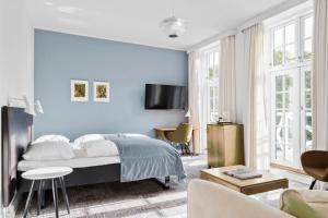 a blue bedroom with a bed and a living room at Gl Skovridergaard in Silkeborg