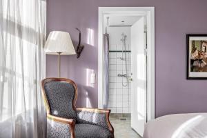 a bedroom with a chair and a shower at Gl Skovridergaard in Silkeborg +120 photos