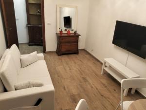 a living room with a white couch and a flat screen tv at Argent House Orbetello in Orbetello