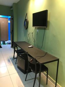a table with chairs and a television on a wall at Pousada Madre De Deus in Brejo da Madre de Deus