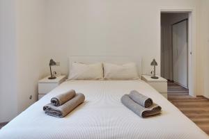 a bedroom with a white bed with towels on it at Otto Violini - City Center in Cremona