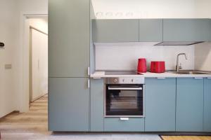 a kitchen with blue cabinets and a stainless steel refrigerator at Otto Violini - City Center in Cremona