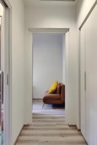 a living room with a brown couch in a hallway at Otto Violini - City Center in Cremona +19 photos