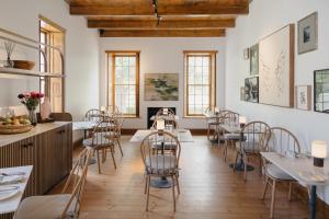 a room with tables and chairs in a restaurant at Rickety Bridge Estate in Franschhoek