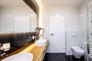a white bathroom with two sinks and a toilet at Villa Lilien Residence Tatry in Veľká Lomnica +45 photos