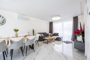 a white living room with a table and chairs at Villa Lilien Residence Tatry in Veľká Lomnica