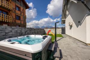 a hot tub on the patio of a house at Villa Lilien Residence Tatry in Veľká Lomnica