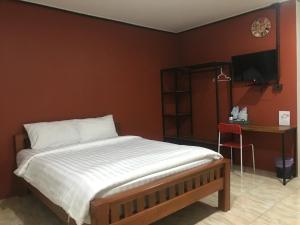 a bedroom with a bed and a desk and a television at ปริญศิริ เพลส2 in Phrae +6 photos