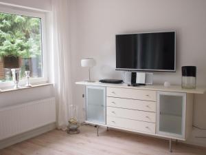 a television on a dresser in a room with a window at Weedkroog in Timmendorfer Strand