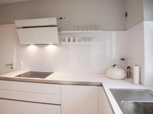 a white kitchen with white cabinets and a sink at Weedkroog in Timmendorfer Strand