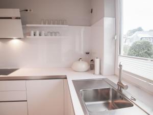 a white kitchen with a sink and a window at Weedkroog in Timmendorfer Strand +24 photos