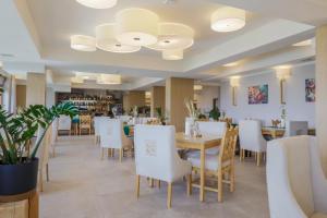 a dining room with white chairs and a tables and chairs at HOTEL*** NAT Bukowina Tatrzańska in Bukowina Tatrzańska