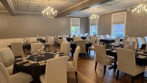 a dining room with tables and chairs and chandeliers at The White Inn in Fredonia