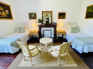 a room with two beds and two chairs and a fireplace at Le Manoir des Doyens in Bayeux