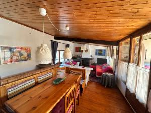 a dining room with a table and a living room at Peyre in Alás