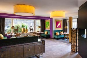 a salon with purple walls and yellow chandeliers at Waldhotel Bärenstein in Horn-Bad Meinberg