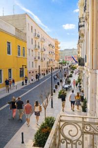 a group of people walking down a city street at Le Gemme Rooms in Matera