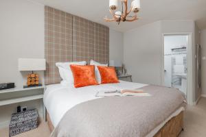 a bedroom with a large bed with orange pillows at LUXURIOUS Country Rooms in Hurley - THE FOX in Hurley