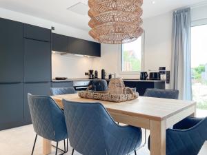 a kitchen with a wooden table and blue chairs at Hygge Hus 2 in Timmendorfer Strand