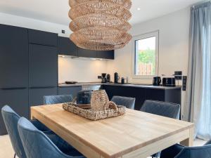 a dining room with a wooden table and blue chairs at Hygge Hus 2 in Timmendorfer Strand