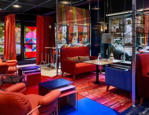 a restaurant with red furniture and a table and chairs at Generator Stockholm in Stockholm
