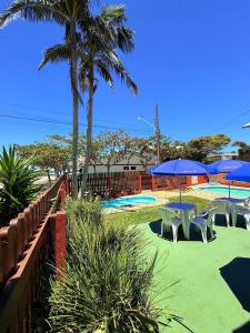a group of tables and chairs with umbrellas at Residencial da Villa in Imbituba
