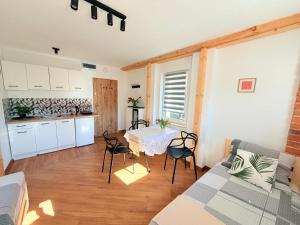 a living room with a table and a kitchen at Noclegi Świerzawa 43 in Świerzawa