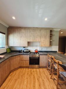 a kitchen with wooden cabinets and a stove top oven at Breede340 - Living the Breede in Malgas