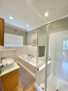 a bathroom with a shower and a tub and a sink at Breede340 - Living the Breede in Malgas +45 photos