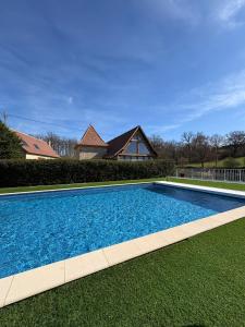 a large blue swimming pool in front of a house at Jolie Roulotte in Issendolus
