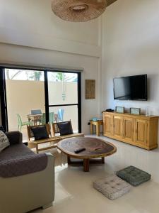 a living room with a coffee table and a flat screen tv at The San Juan House in san juan la union