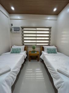 two beds in a small room with a table at The San Juan House in san juan la union +36 photos