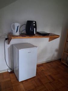 a small white refrigerator sitting on a wooden shelf at Die Eend Studio in Centurion