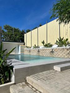 a swimming pool in front of a fence at The San Juan House in san juan la union