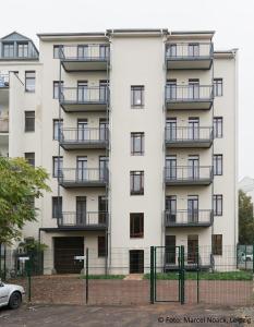 ライプツィヒにあるCity Park Apartments - #16, #18 & D - Moderne Apartments & Suiten im Zentrumのバルコニーとフェンス付きのアパートメントビル