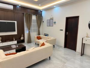 a living room with two couches and a flat screen tv at Appartement Kekely in Yovo Kopé