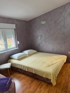 a bedroom with a large bed in a room at Apartmani Palma in Sutomore
