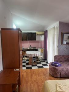 a living room with a table and a kitchen at Apartmani Palma in Sutomore
